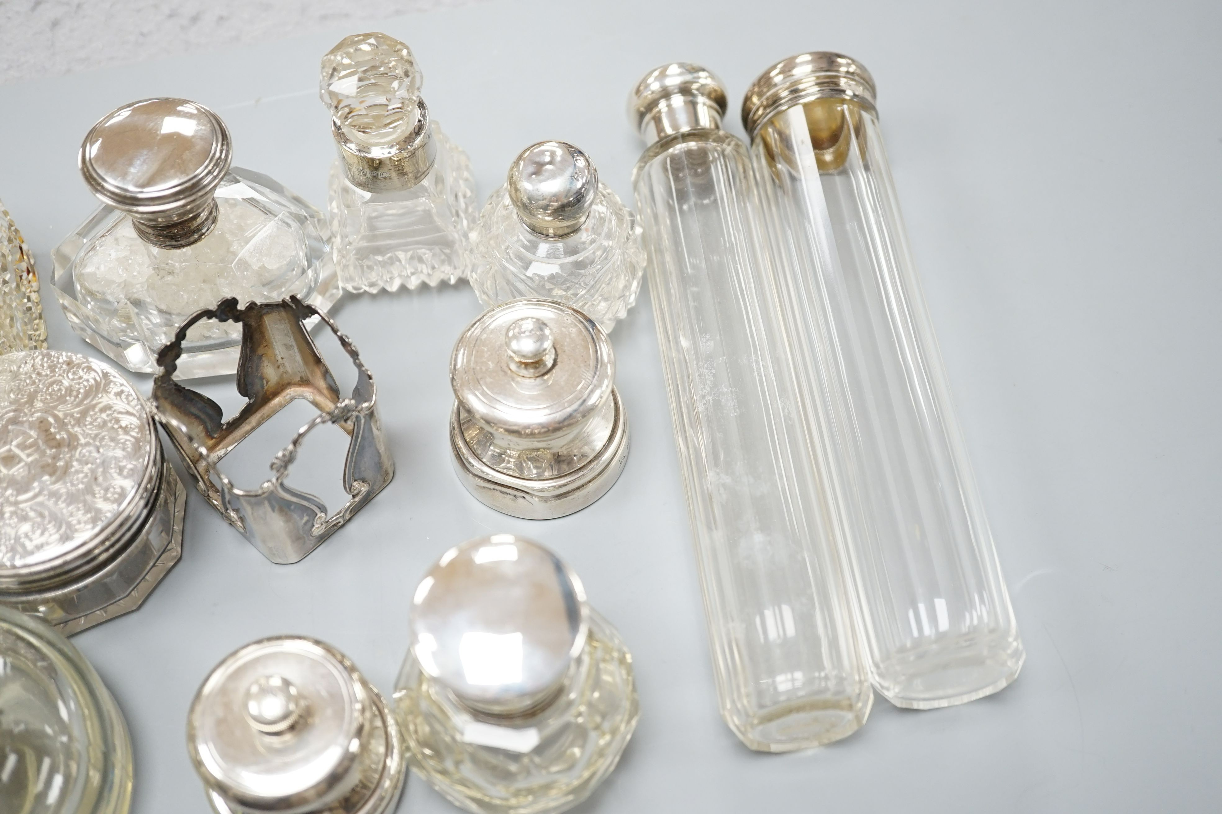 A collection of twelve assorted silver mounted glass toilet jars including Victorian, a plate mounted inkwell and a small pair of silver mounted salt and pepper mills.